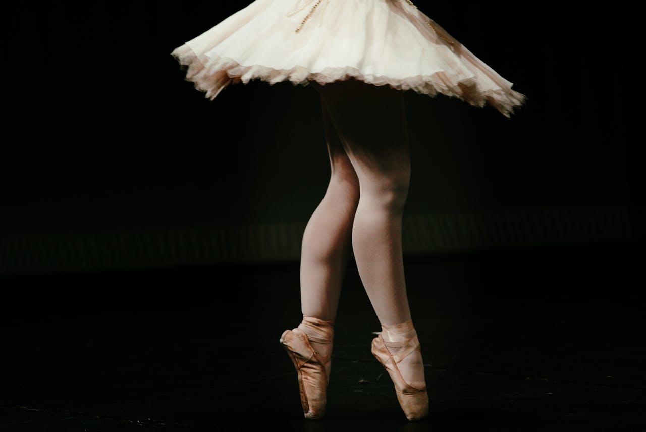 The Art of Drawing Readers In: Your attractive post title goes here Close-up of a ballerina's legs in pointe shoes performing on stage, showcasing graceful movement.